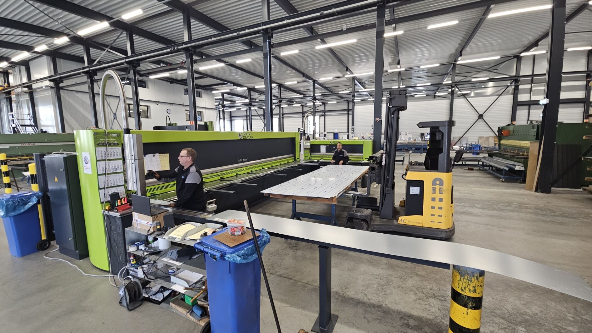 Medewerkers aan de plaatschaar in de werkplaats